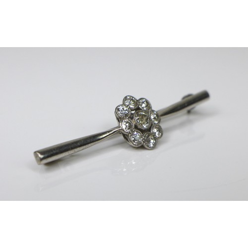 246 - An 18ct white gold and diamond brooch, the central setting of flowerhead form, 12.5mm diameter, on a... 