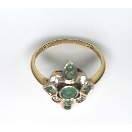 217 - An 18ct gold, emerald and white stone dress ring, the quatrefoil setting with seven emeralds, the ce... 