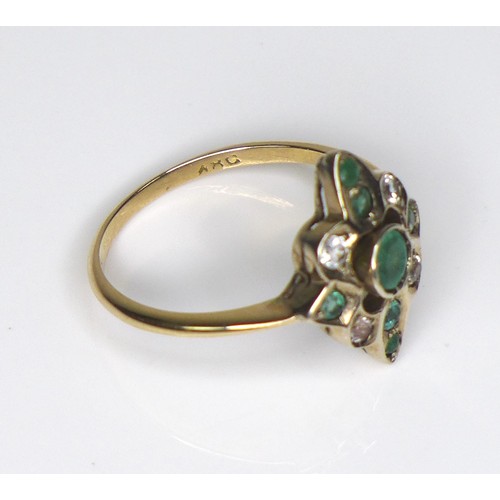 217 - An 18ct gold, emerald and white stone dress ring, the quatrefoil setting with seven emeralds, the ce... 