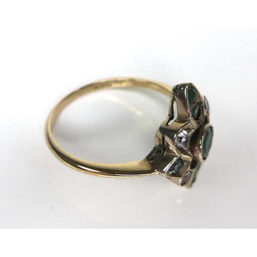 217 - An 18ct gold, emerald and white stone dress ring, the quatrefoil setting with seven emeralds, the ce... 