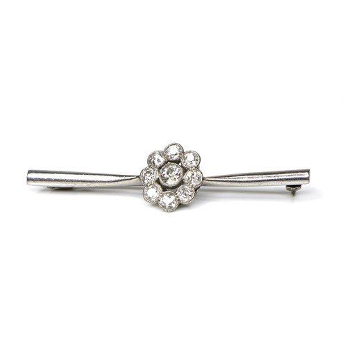 246 - An 18ct white gold and diamond brooch, the central setting of flowerhead form, 12.5mm diameter, on a... 