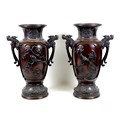 A pair of large Japanese bronze twin handled vases, Meiji period, decorated in high relief with pane... 