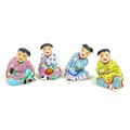 A group of four Chinese figures, late 20th century, each modelled as a seated child, smiling whilst ... 