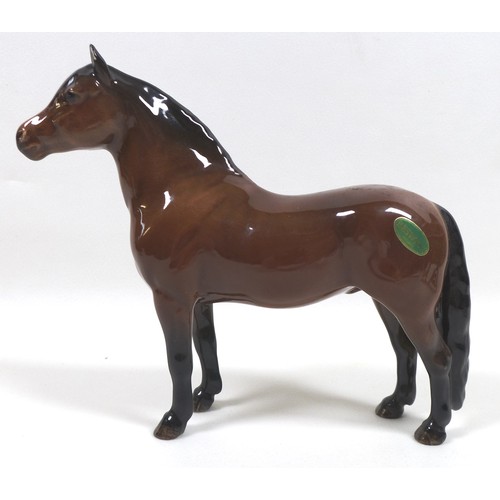 94 - A group of four Beswick horses, including two 'Pony (Head up)', model 1197, brown - gloss, 14cm high... 