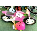 A KiddiMoto children's wooden balance bike, in the form of a pink motorbike, together with a matchin... 