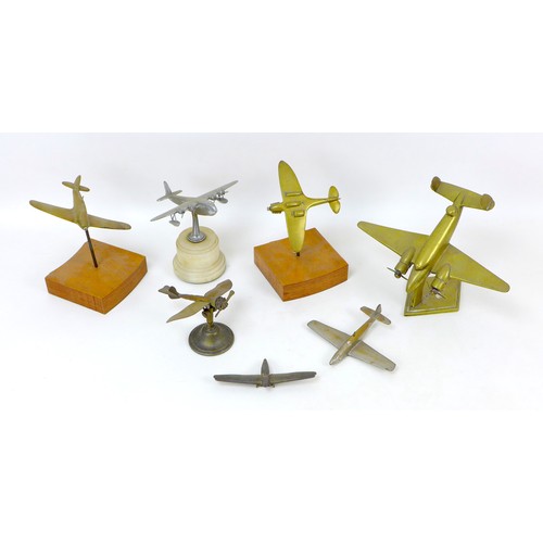 106 - Seven cast metal models of WWI and later aircraft, including a brass Spitfire, 15 by 12 by 3cm high,... 