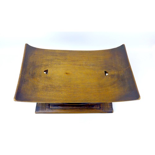 137 - A 20th century African style tribal hardwood stool, with sloping seat, pierced decoration to its cen... 