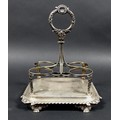 A George III silver cruet stand, with shell mounted handle, monogram to base and scroll decorated ri... 