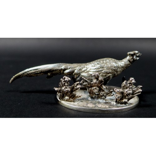 14 - An early 20th century German silver table sculpture, modelled as a cock pheasant walking amongst flo... 