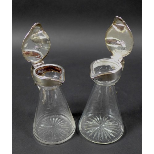 34 - A pair of Edwardian clear glass and silver mounted noggin flasks, each of tapering form with mounted... 