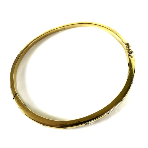 372 - An 18ct gold and diamond bangle, set with thirteen graduated brilliant cut stones, hinge clasp, 6cm ... 