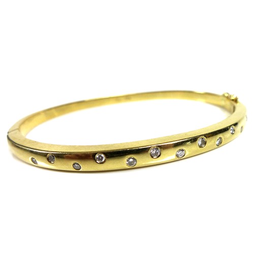 372 - An 18ct gold and diamond bangle, set with thirteen graduated brilliant cut stones, hinge clasp, 6cm ... 