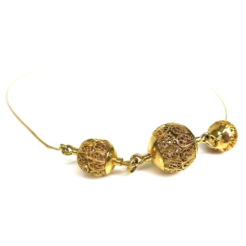 366 - An 18ct gold filigree necklace, the central bead of approximately 1.4cm diameter and flanked by two ... 