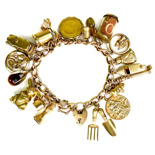 375 - A 9ct yellow gold charm bracelet, kerb link with heart padlock clasp, all links marked, fitted with ... 