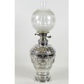 A large and impressive 19th century silver paraffin lamp, of ovoid form with all over repousse decor... 