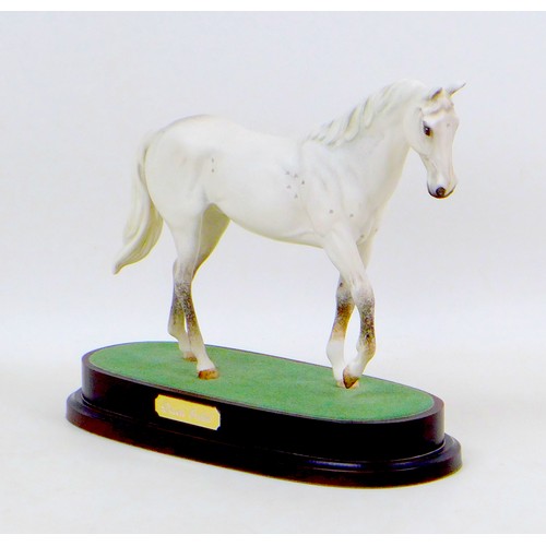 38 - A Royal Doulton figurine of the racehorse Desert Orchid, raised upon a wooden plinth, 27 by 12 by 22... 