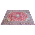 A large Araak rug, with red ground, central dark blue and cream floral medallion, central field dens... 