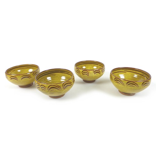 18 - Clive Bowen (British, b. 1943): a set of four Studio pottery bowls, yellow and brown slip glaze, eac... 