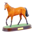 A Royal Doulton figurine of the racing horse Red Rum, raised upon a wooden plinth, 25.5 by 10.5 by 2... 