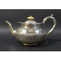 A Victorian silver teapot, with a bone finial, half gadrooned decoration to its lid and base, an eng... 