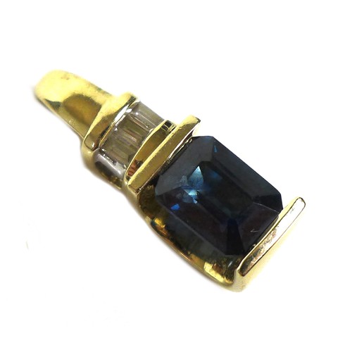 106 - A 14ct gold, synthetic sapphire, and diamond pendant, the royal blue emerald cut synthetic sapphire,... 