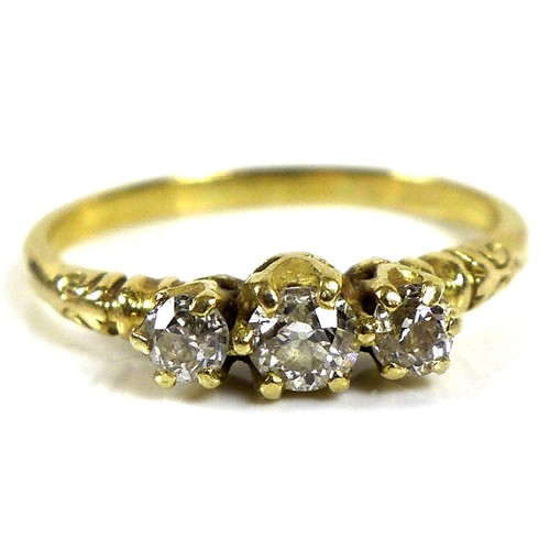 180 - A yellow gold three stone diamond ring, the central brilliant round cut stone of 3.4mm flanked by tw... 