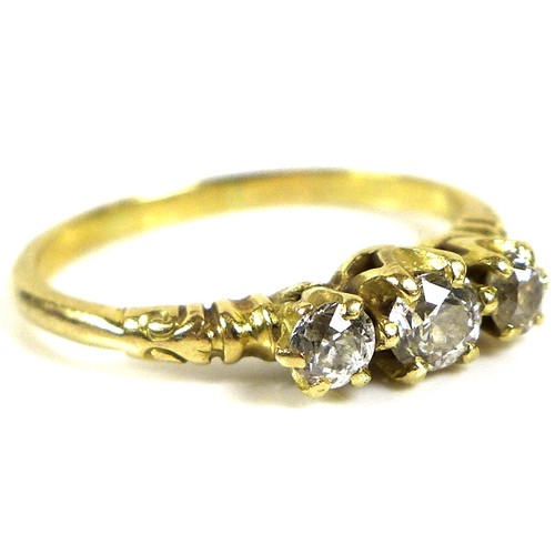 180 - A yellow gold three stone diamond ring, the central brilliant round cut stone of 3.4mm flanked by tw... 