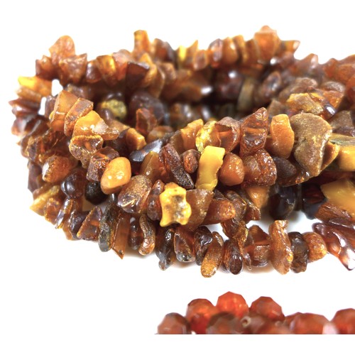 105 - A rough hewn amber necklace, 190cm long overall, 98.4g, together with a another amber style necklace... 