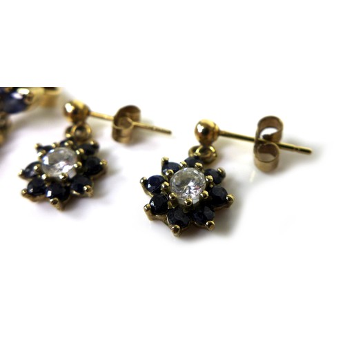 87 - Two pairs of gold and sapphire drop stud earrings, the first of flowerhead design with central white... 