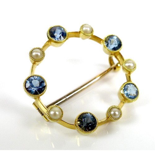 117 - A 15ct gold, sapphire and pearl brooch, of opal circle design with five beaded rubover set cornflowe... 