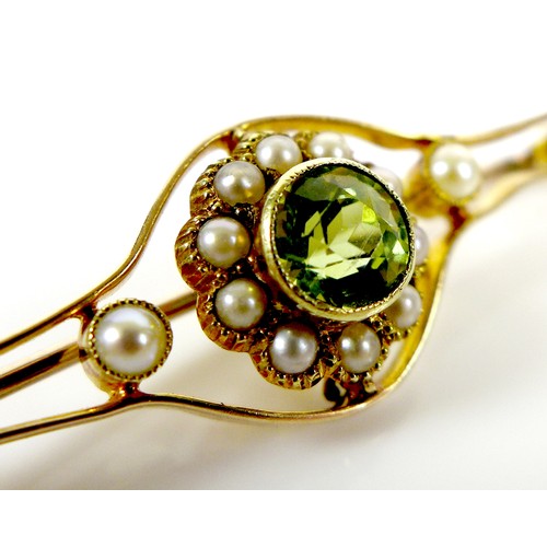 118 - A 15ct gold, peridot and pearl open bar brooch, the central stone of 0.5cm diameter and surrounded b... 