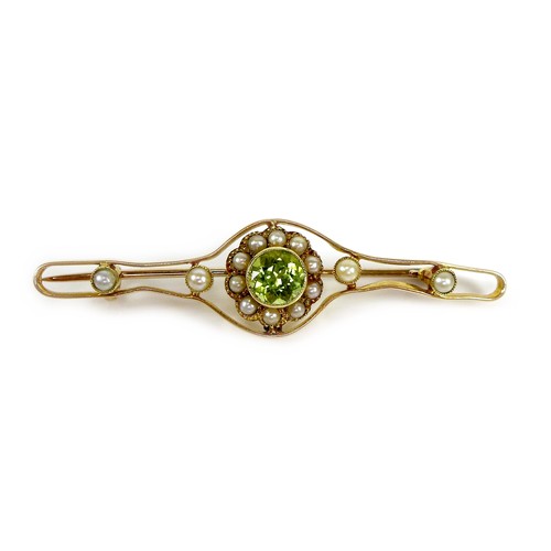 118 - A 15ct gold, peridot and pearl open bar brooch, the central stone of 0.5cm diameter and surrounded b... 