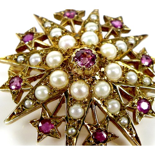 112 - A 9ct gold, ruby and pearl starburst brooch, 3.1cm diameter, 5.4g.