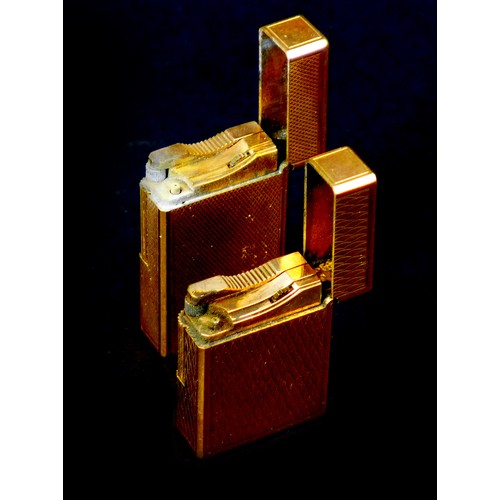 110 - Two retro Dupont gold plated lighters, the largest, 6cm long, with machine turned decoration, origin... 