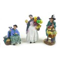 A group of three Royal Doulton china figurines, comprising 'The Mask Seller', HN2103, 21.5cm high, '... 