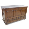 An 18th century oak mule chest, with three carved panels to the front, over two drawers, raised on s... 