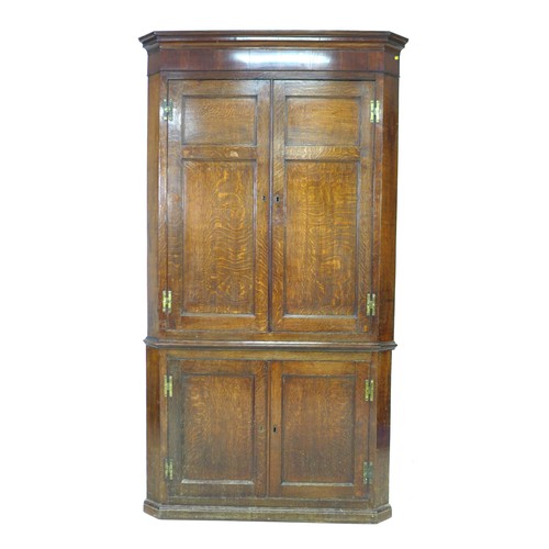 238 - A George III oak and mahogany corner cupboard, floor-standing, with panelled doors and shelved inter... 