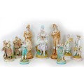 Nine large 19th century style bisque figurines, depicting ladies and gentleman in 18th/19th century ... 