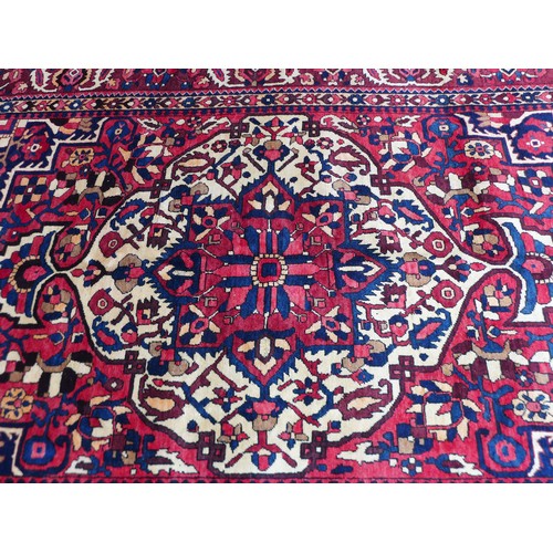 230 - A Bakhtiar carpet with red ground, with cream central medallion with pendant anchors, densely decora... 