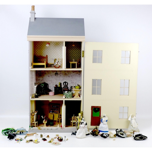 130 - A mid 20th century dolls house, with a single hinged door concealing a three storey interior, togeth... 