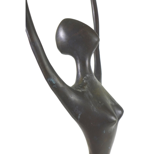 143 - An abstract bronzed female figurine of elongated form, raised upon a stepped mahogany base, unsigned... 