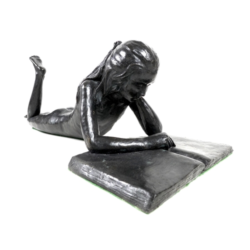 148 - A modern bronzed resin sculpture, modelled as nude girl lying on her front reading a book, unsigned,... 