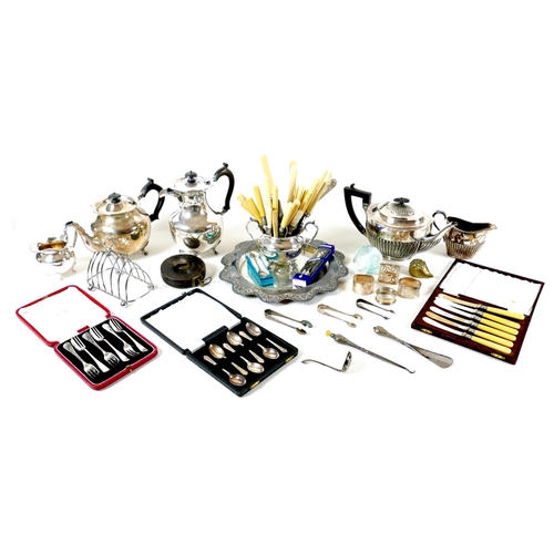 155 - A group of silver plated items, including three teapots, flatware, a trays, flatware, and a toast ra... 