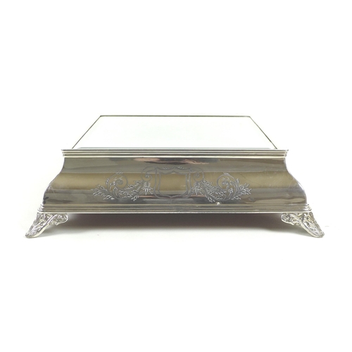 157 - An early 20th century silver plated wedding cake stand, of square form with bevelled mirror surface,... 