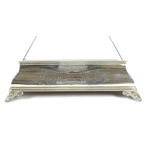 157 - An early 20th century silver plated wedding cake stand, of square form with bevelled mirror surface,... 