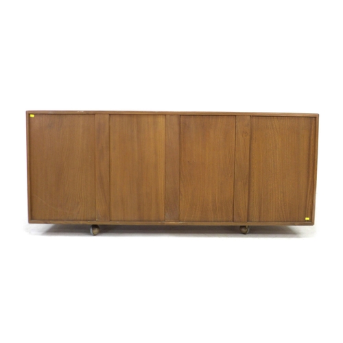 210 - An Ercol elm sideboard, with three central drawers flanked by two cupboards, all with recessed oval ... 