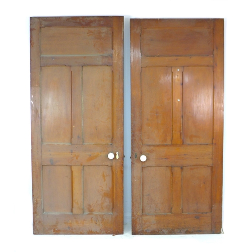 214 - A pair of five panelled stained pine doors with ceramic round handles and escutcheons, 91 by 4 by 21... 