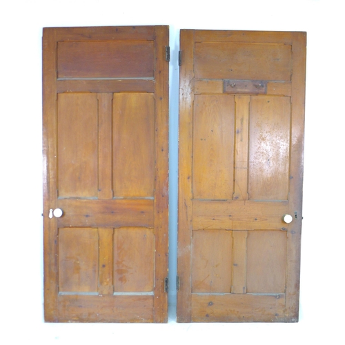 214 - A pair of five panelled stained pine doors with ceramic round handles and escutcheons, 91 by 4 by 21... 