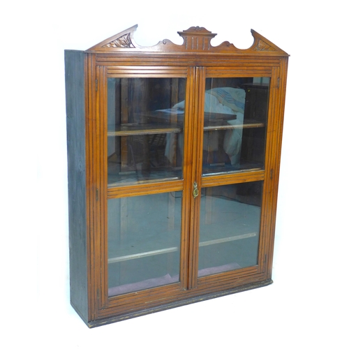 216 - A late Victorian mahogany display cabinet, with carved pediment, twin glazed doors, three adjustable... 