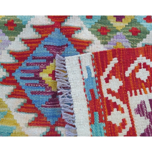 223 - A vegetable dye Chobi Kilim rug, featuring a colourful geometric design to its centre, with orange a... 